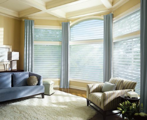 A living room with two large windows and a couch.