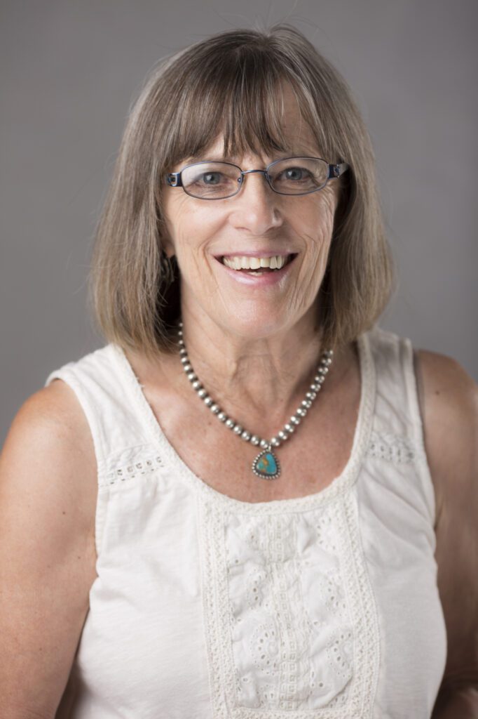 A woman wearing glasses and a necklace.