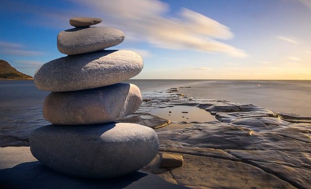 A stack of rocks on the beach near water.